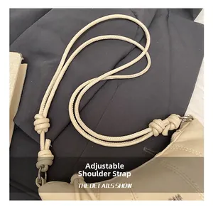 Detail shot of the adjustable knotted leather shoulder strap on a beige dumpling bag