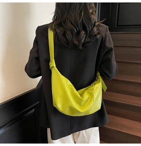 Fluorescent green hobo crossbody bag featuring knotted strap details and textured leather