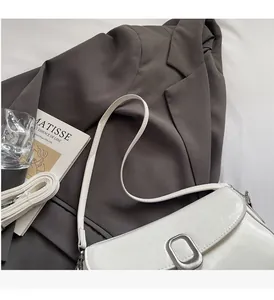 Detail of white saddle bag with cracked texture, silver buckle and dual straps