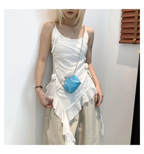 Close-up of bright blue shell crossbody bag with silver chain and white stitching