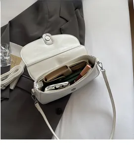 Interior view of white leather saddle bag showing ample space for phone and makeup