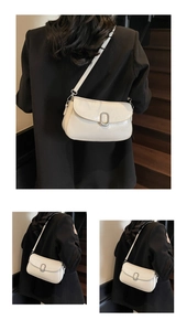 Detail view of cream rectangle crossbody bag with silver buckle on minimalist leather