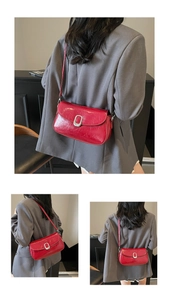 Macro detail of red saddle bag featuring a glossy texture and silver oval clasp