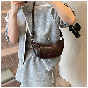 Detail of dark brown leather croissant bag with knotted strap and COIN 'RDN logo