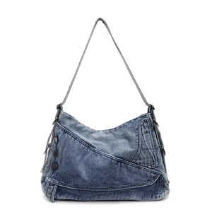 Vintage blue washed denim tote bag with asymmetric flap and metal buckles on white background