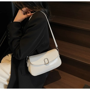 Chic white baguette bag with glossy crinkle texture and silver buckle shown on shoulder