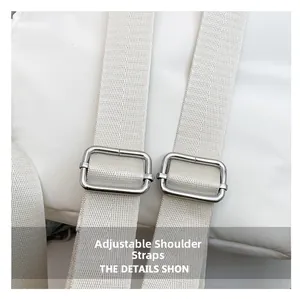 Detalle de las correas blancas ajustables con hebillas de metal plateado en la mochila