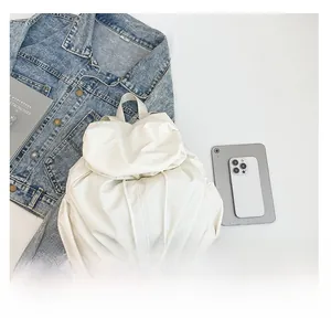 Detalle de mochila blanca plisada con cordón, mostrando textura suave y estilo casual moderno