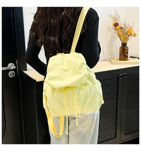 Close-up of lightweight light yellow nylon backpack with flap and drawstring closure