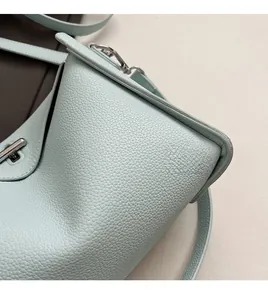 Macro shot of mint green lychee grain leather with silver twist lock and stitching
