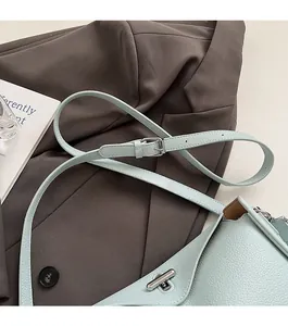 Detail of adjustable strap and silver buckle on a light blue pebble leather handbag