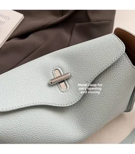 Detail of silver twist lock on light blue lychee pattern leather handbag with easy closure