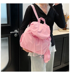 Detalle de la mochila rosa claro con textura de nailon plisado y cierre de cordón