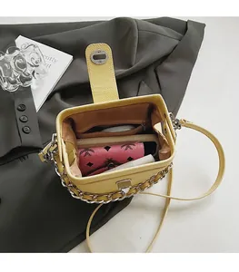 Open view showing internal capacity of yellow lychee leather bag with metal chain detail