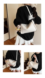Three-way view of a white lychee grain crossbody bag with metal lock and plush charm