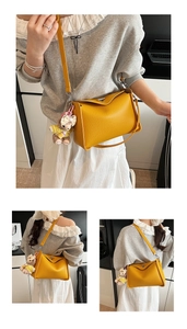 Detail of yellow lychee texture shoulder bag with cute bear charm and adjustable strap