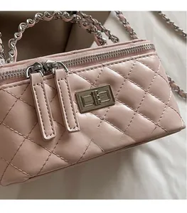Detailed macro view of pink quilted leather bag with silver metal buckle and chain strap