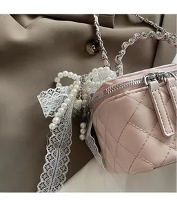 Pink quilted leather bag side detail with elegant pearl and white lace charms