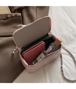 Pink quilted crossbody bag interior showing storage space for phone, cardholder and perfume