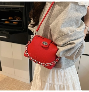 Red lychee grain leather crossbody bucket bag with silver chain and twist-lock detail