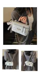Macro detail of quilted grey mini bag with metal chain strap and pearl lace bow