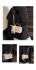 Close-up of pink quilted bag with lace bow, pearl accents and silver chain strap