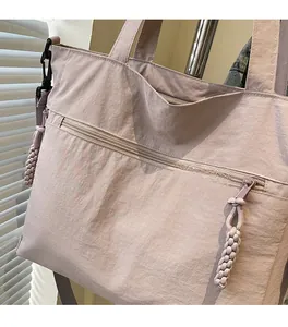 Close-up of a lilac nylon tote bag featuring wrinkled texture and woven zipper detail