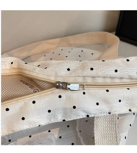 Détail de la fermeture éclair et du motif à pois noirs sur le grand sac cabas