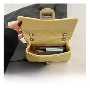 Internal view of a yellow quilted bag showing capacity for phone and makeup