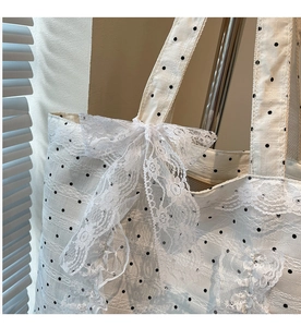 Détails d'un sac cabas à pois blancs avec dentelle multicouche et nœud élégant