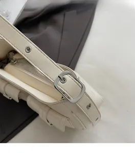Dettaglio della borsa a spalla in pelle lucida bianco crema con fibbia e hardware argento