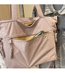 Detail of lavender nylon tote bag showing front zipper pocket and phone storage space