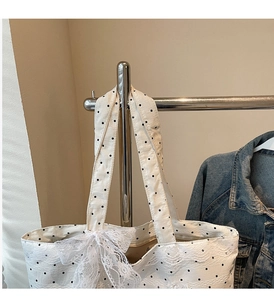 Détail du sac cabas blanc à pois avec bordure en dentelle et nœud décoratif