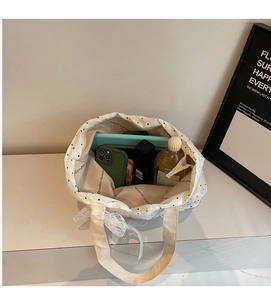 Intérieur spacieux du cabas en toile à pois contenant un iPad et des cosmétiques