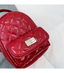 Close-up of red quilted glossy mini backpack with silver metal twist-lock buckle detail