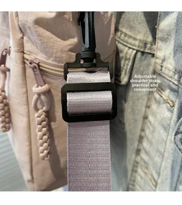 Detail of adjustable gray nylon shoulder strap with durable black plastic buckle on tote