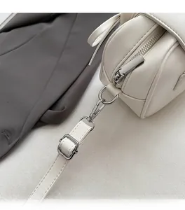 Details des silbernen Metallreißverschlusses und der Schnalle an der cremefarbenen Tasche