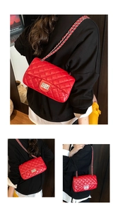 Detail of red quilted leather crossbody bag featuring silver chain strap and metal lock
