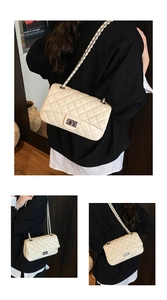 Detail of quilted diamond pattern and metallic twist lock on creamy white flap bag