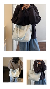Detail of light blue nylon tote bag with zipper closure and side woven tassel accents