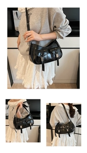 Dettaglio borsa sottospalla in pelle lucida nera con fibbie argentate e doppie tasche