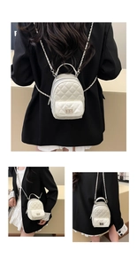 Detailed back view of white quilted mini backpack with silver chain straps and top handle