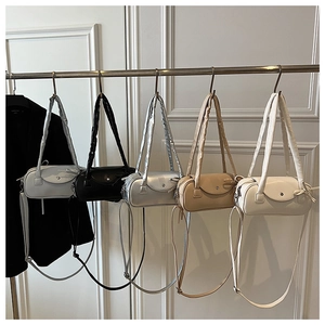 Reihe bunter Zylinder-Taschen in Weiß, Silber und Schwarz mit verstellbarem Schultergurt