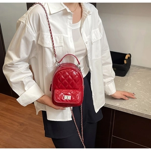 Detail of red quilted patent leather mini bag with gold twist lock and chain strap