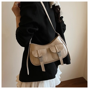 Dettaglio della borsa beige lucida con tasche a patta e fibbie in metallo argentato