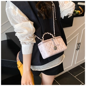 Detailed view of pink quilted crossbody bag with silver studs and chain strap