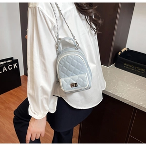 Detail of light blue quilted mini backpack with silver chain straps and turn-lock pocket