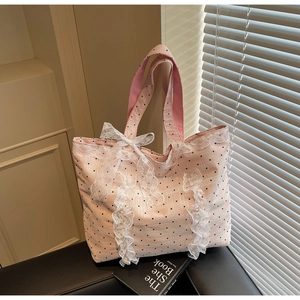 Détail du sac cabas rose à pois avec bordure en dentelle blanche et un grand nœud déco