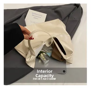 Detailed internal capacity showing tablets and cosmetics inside the beige tote bag