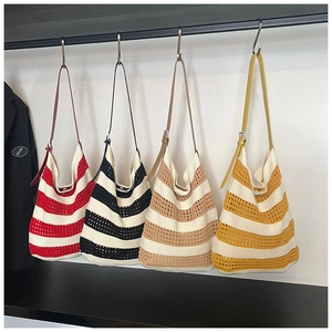 Row of colorful crochet tote bags in red, black, khaki, and yellow striped patterns